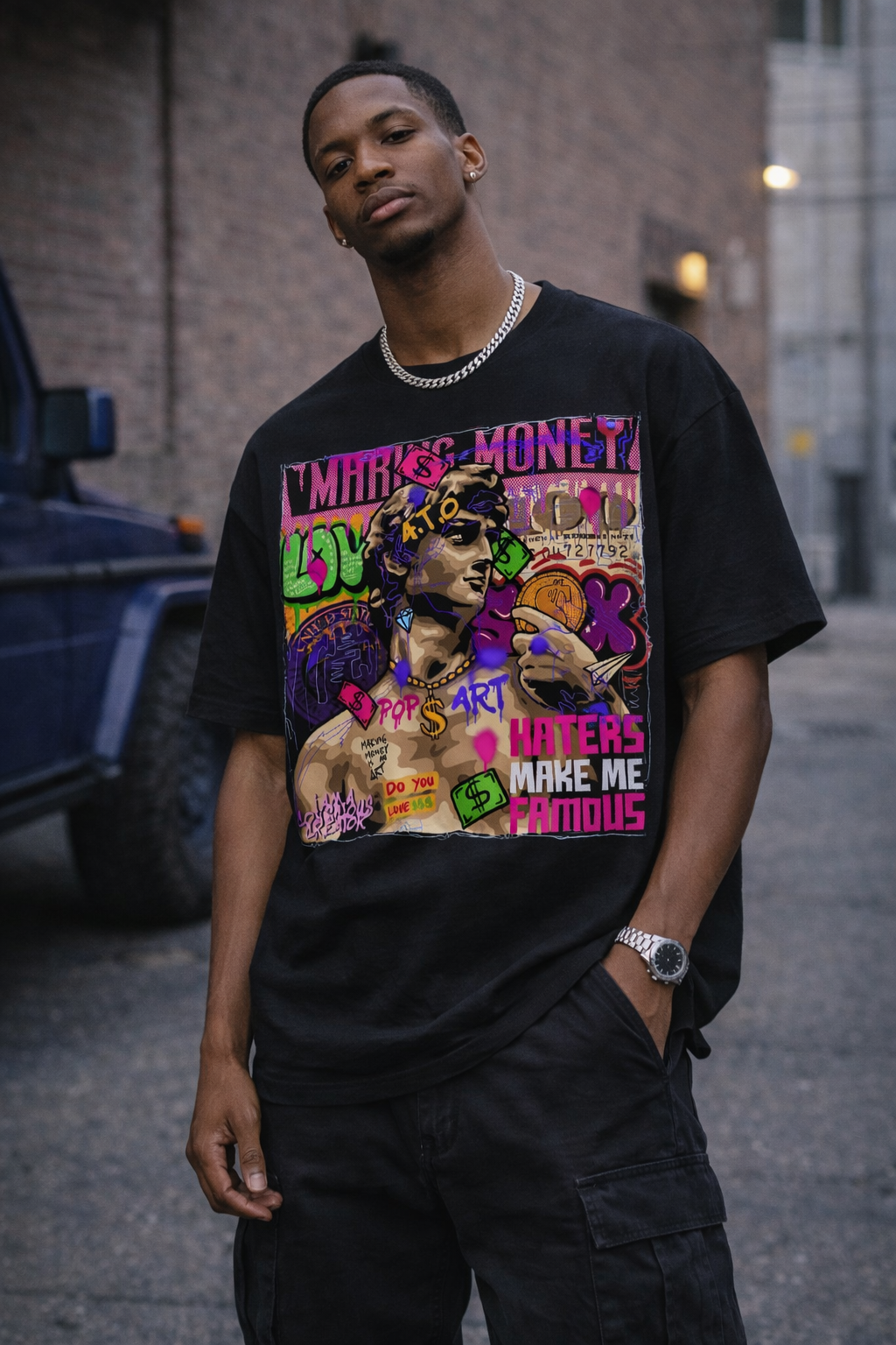 Person wearing a black t-shirt with colorful graphic design on a street.