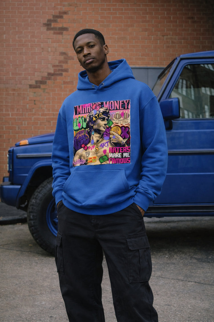 Person wearing a blue hoodie with a colorful graphic design in front of a blue truck.