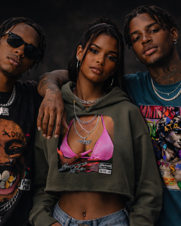 Three people posing together against a dark background